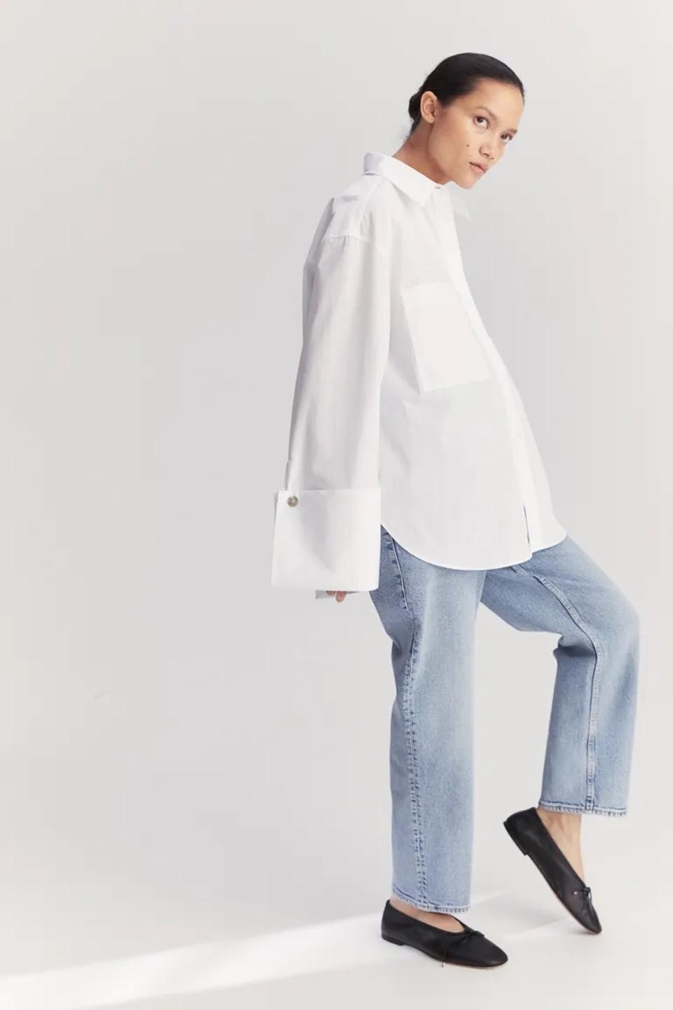 A brunette woman wearing the H&M Mama Straight Ankle Jeans in white on a white background