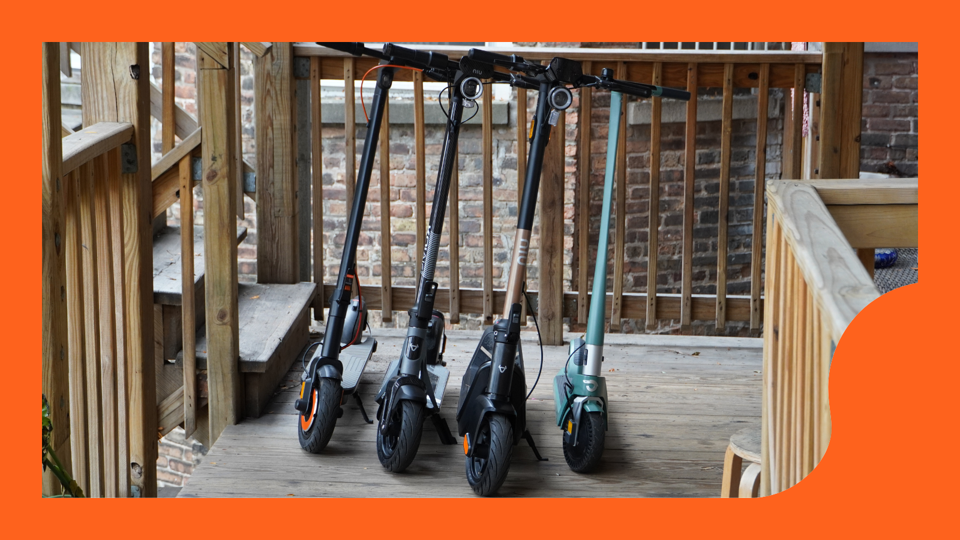 Four electric scooters lined up next to one another on a back porch