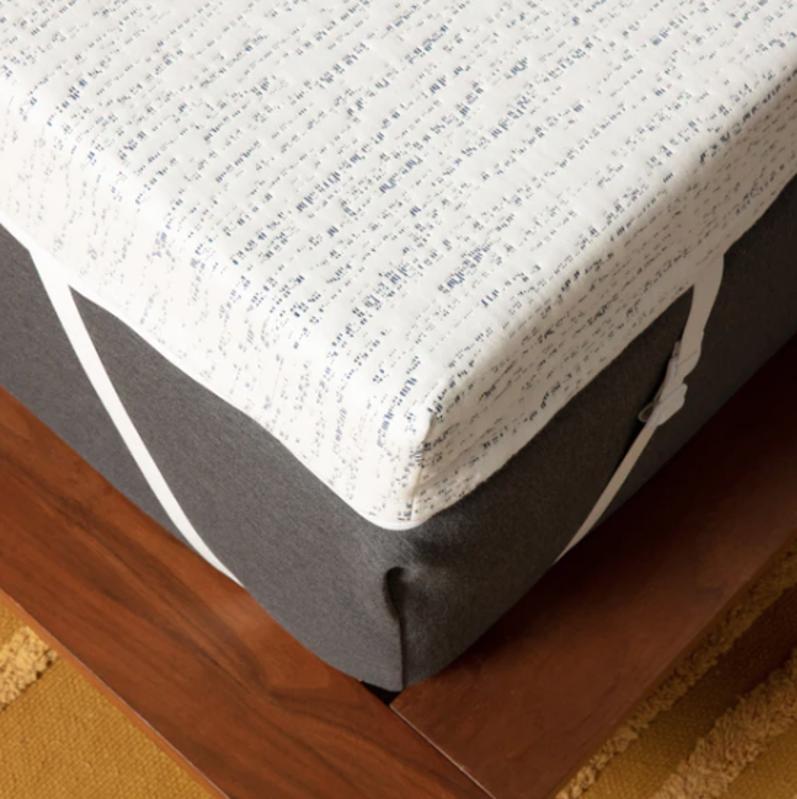 The Select High Density Mattress Topper strapped onto a mattress. 