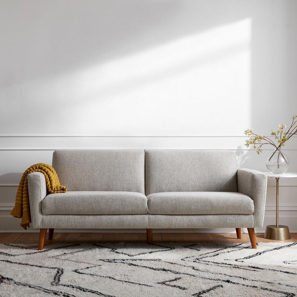 The West Elm Oliver Sofa in a living room with a cream colored rug