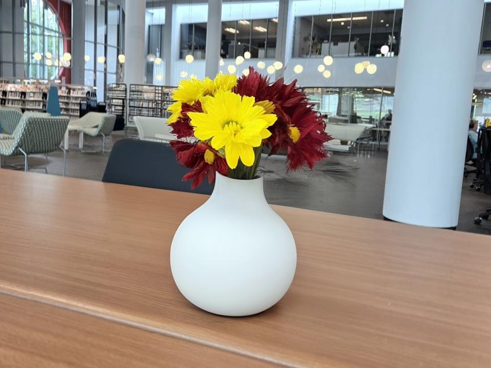 An AI generated vase with flowers on a table.