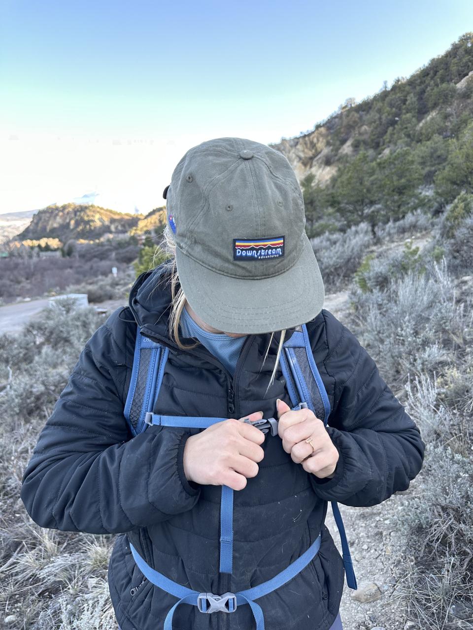 Person wearing the Osprey Daylite Daypack and buckling the front chest strap