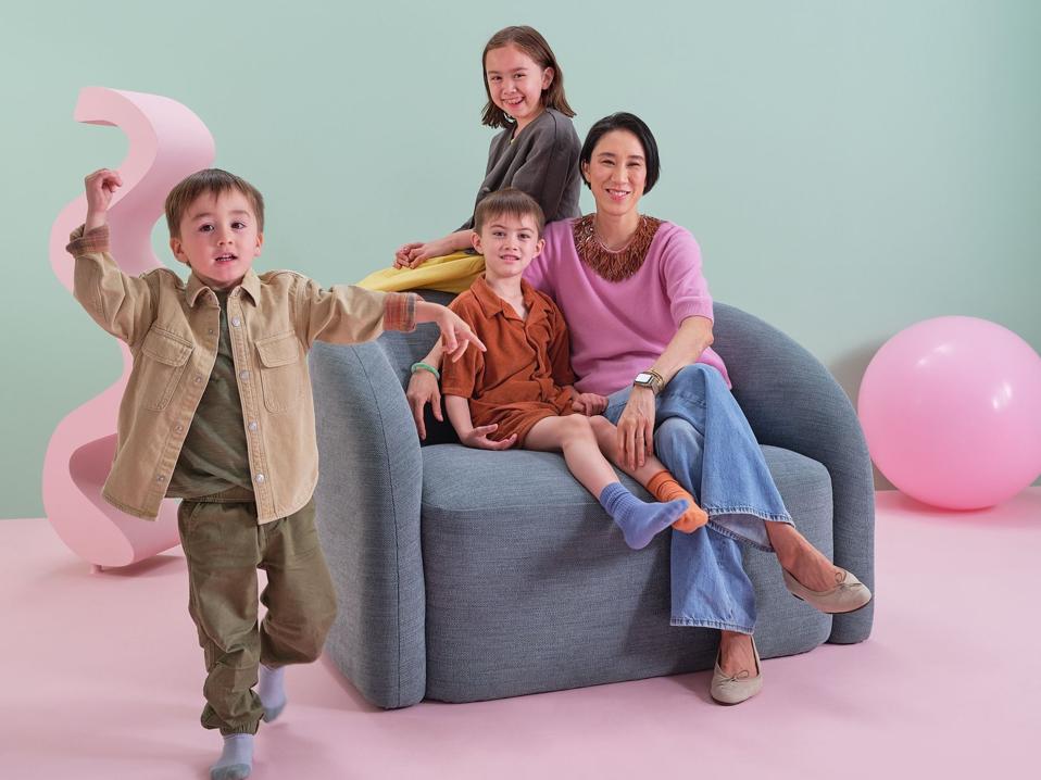 Eva Chen with children on a new chair that's part of her furniture collection at West Elm.