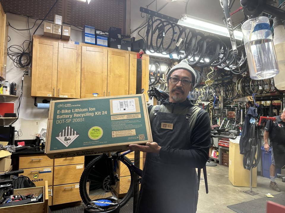 A man holds a box that's designed to shop electric bike batteries