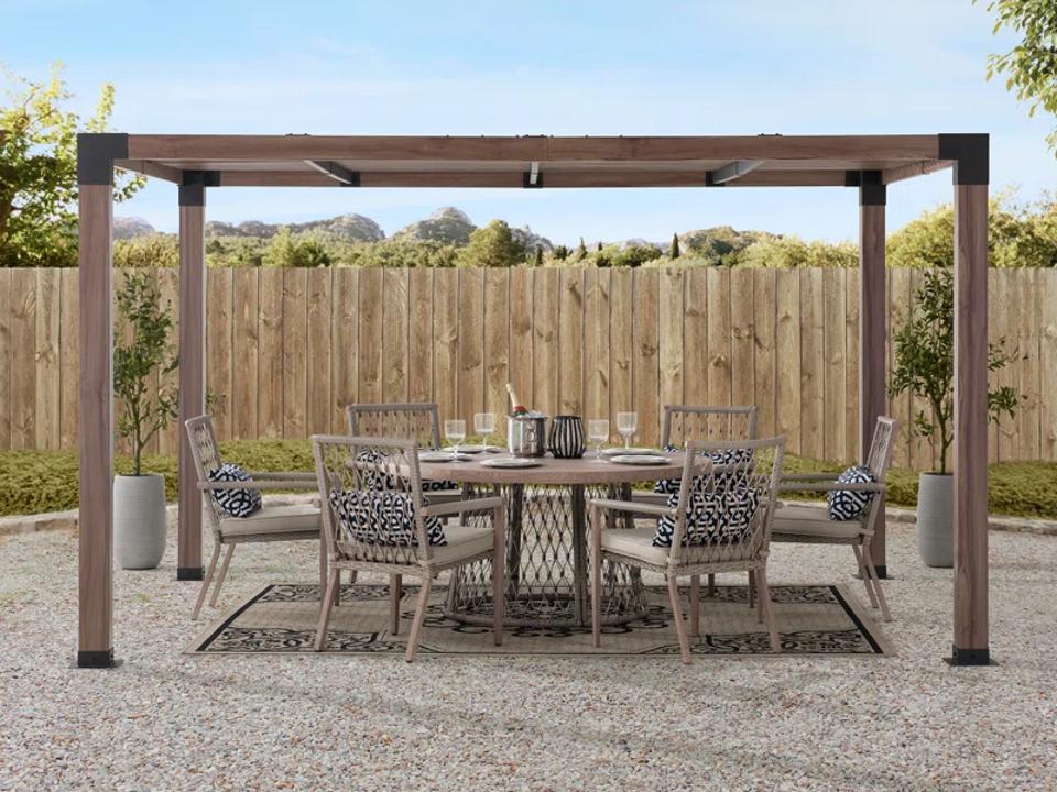 Sunjoy SummerCove Metal Pergola covers table and chair set in backyard.