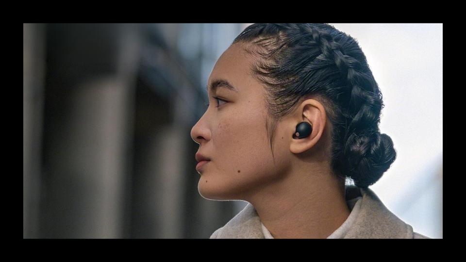 A women wearing one of the best wireless earbuds. 