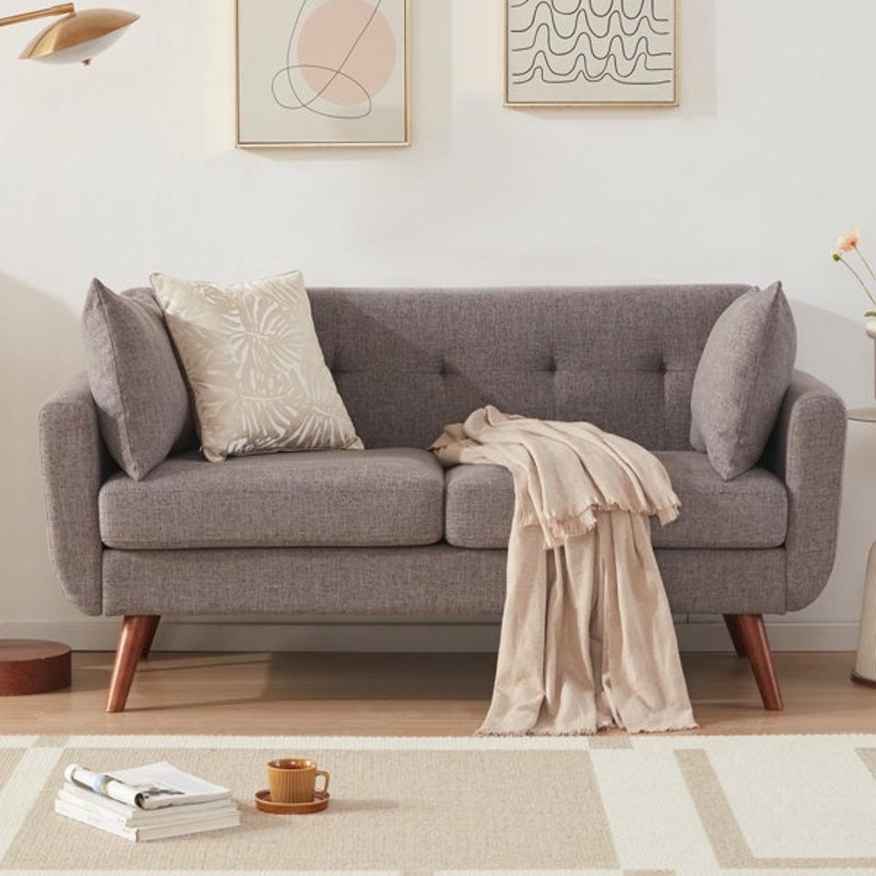 A gray Corrigan Studio Square Arm Loveseat with a tan blanket