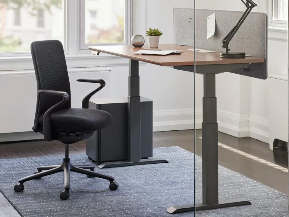 Best desks: Branch Standing Desk gray legs in office behind glass with office chair forbes