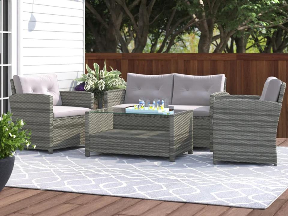 Brayden Studio Anyuta Four-Person Outdoor Seating Group on rug on patio.