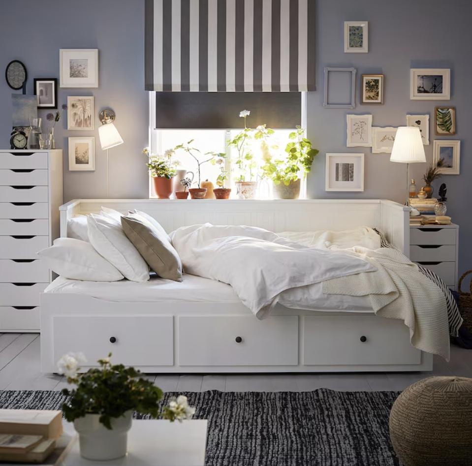 The IKEA Hemnes Dayned in a bedroom with pillows and a blanket on top. 