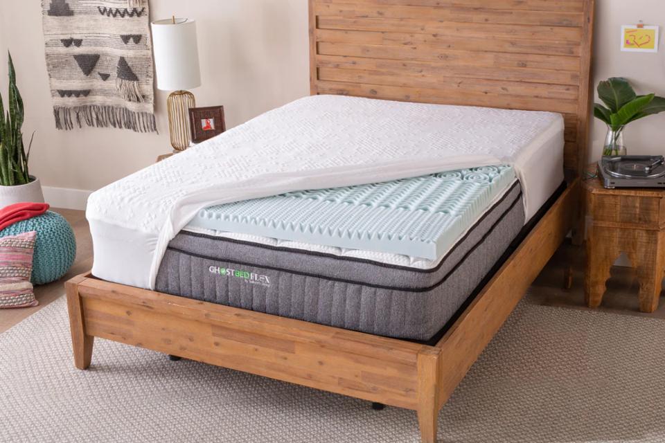 The GhostBed Memory Foam Topper on a GhostBed mattress with a sheet pulled off of it