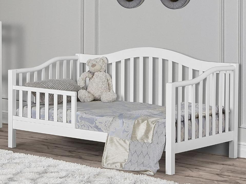 Dream On Me Austin Toddler Day Bed in in a child's room with a big teddy bear on it