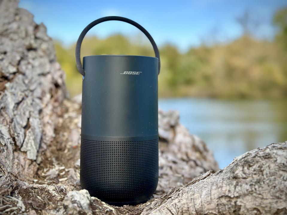 Bose Portable Smart Speaker seated outside by a tree near a lake