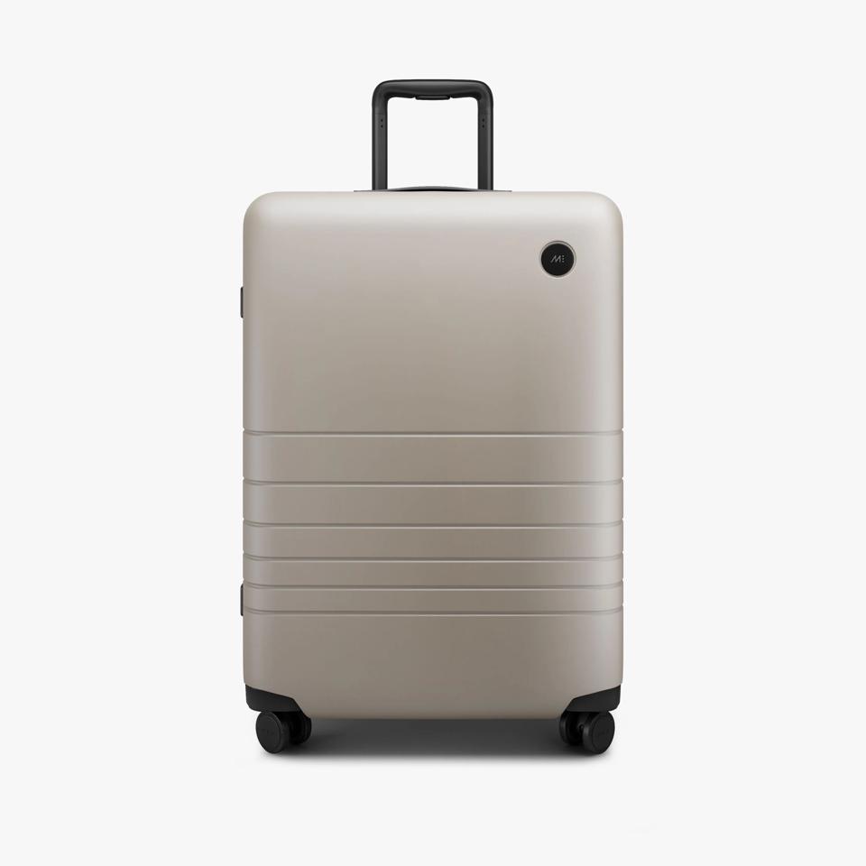 Taupe suitcase against a white background.