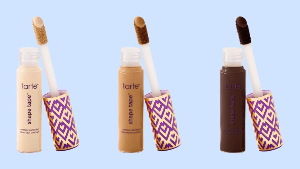 3 bottles of Tarte Shape Tape concealer in different shades on a light blue background. 