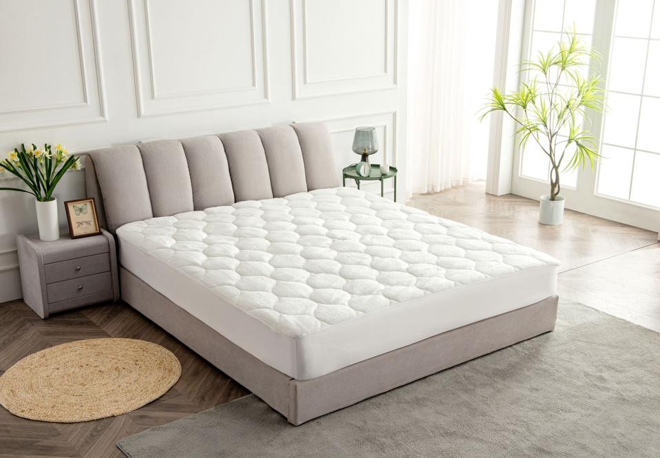 Slumberfy Premium Bamboo Mattress Pad on a light grey bed frame in bright bedroom.