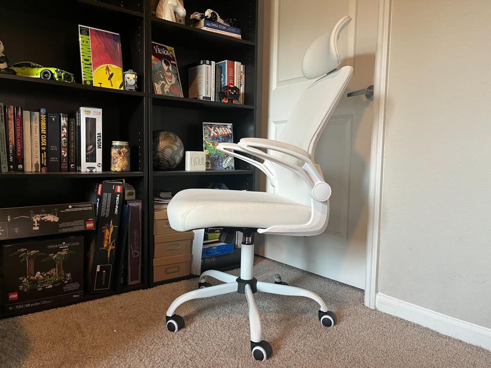 White mimoglad office chair headrest on light brown carpet black bookshelf white door