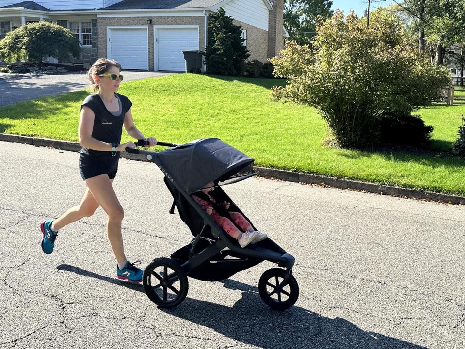 The author running with the Guava Roam and her child on a road.