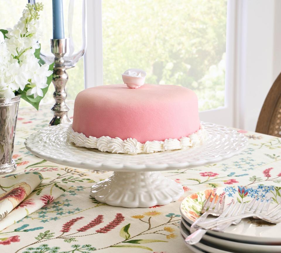 Cake stand with pink cake on top.