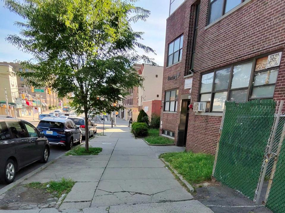 A cityscape of Jersey City showing a sidewalk and brick building.