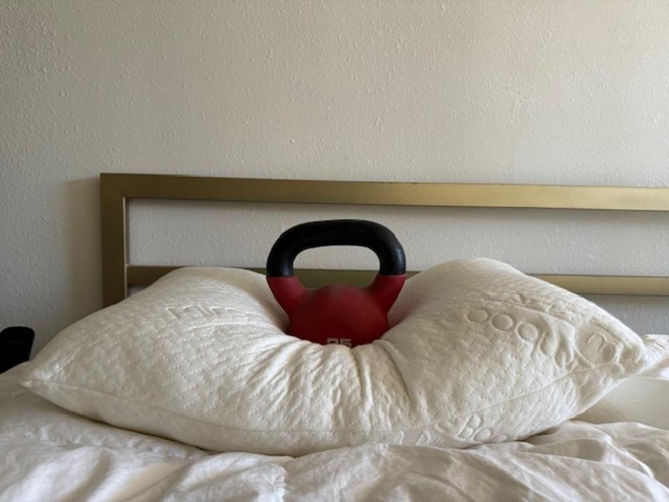 A weight on the middle of the ontel bamboo pillow on a bed