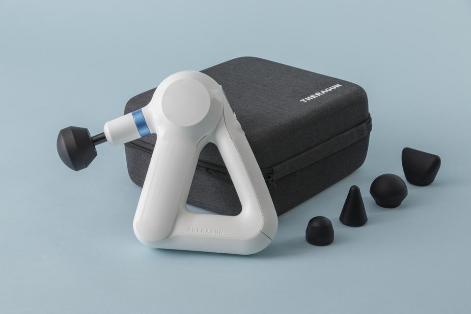 Theragun Elite massage gun with attachment heads on white background