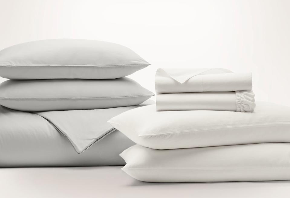 Boll & Branch sheets on a folded duvet comforter and a set of stacked pillows.