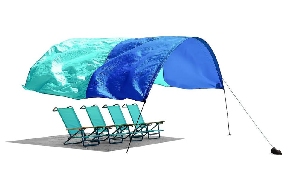 Shibumi Shade in royal blue and teal with four beach chairs underneath