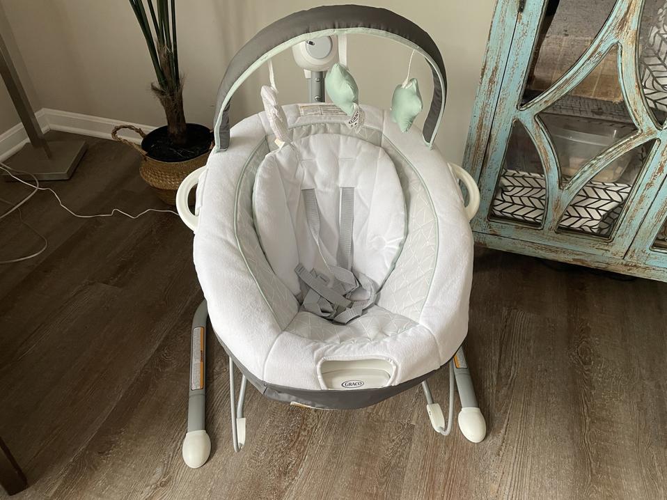 The Graco Soothe ’N Sway LX Swing With Portable Bouncer on the floor in a room.