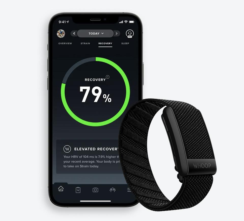 The Whoop Band in black with a phone next to it displaying someone's stats. 