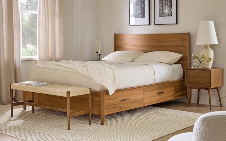 The West Elm Storage Bed with a mattress on top in a brightly lit room. 