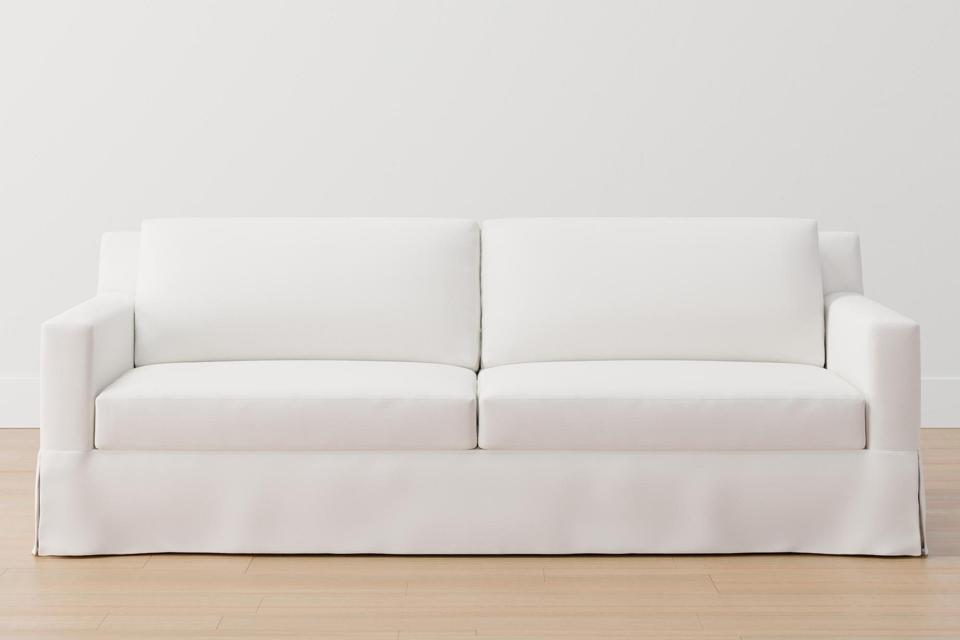 A white Pottery Barn York Square Arm Slipcovered Sofa  in a white room