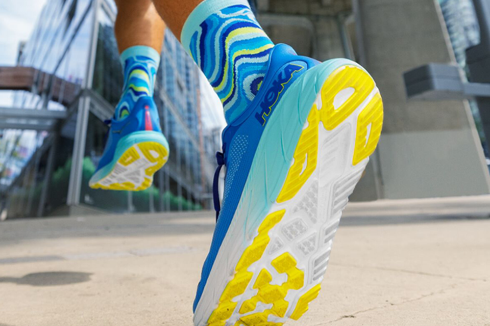 A person wearing the blue and yellow Hoka Arahi 7 running shoes