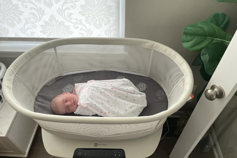 The author's baby sleeping in the 4moms Mamaroo bassinet.