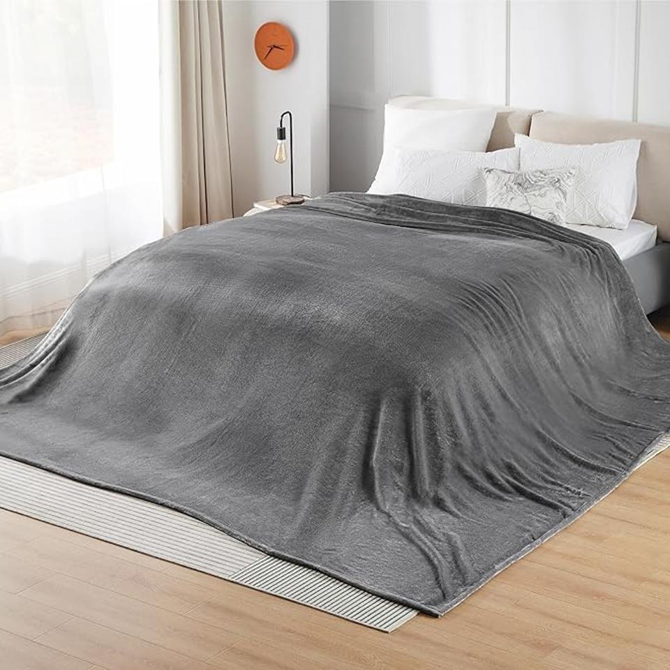 Bedsure Oversized King Fleece Blanket in grey on a bed