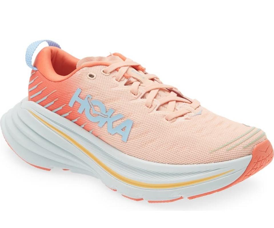 product shot of a Hoka Bondi X sneaker in the Camellia / Peach Parfait colorway.