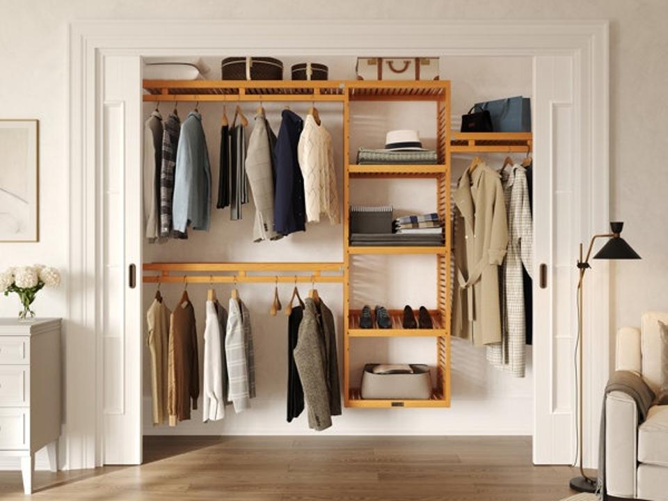 John Louis Home Simplicity Closet System featured inside a reach-in closet filled with clothes and accessories 