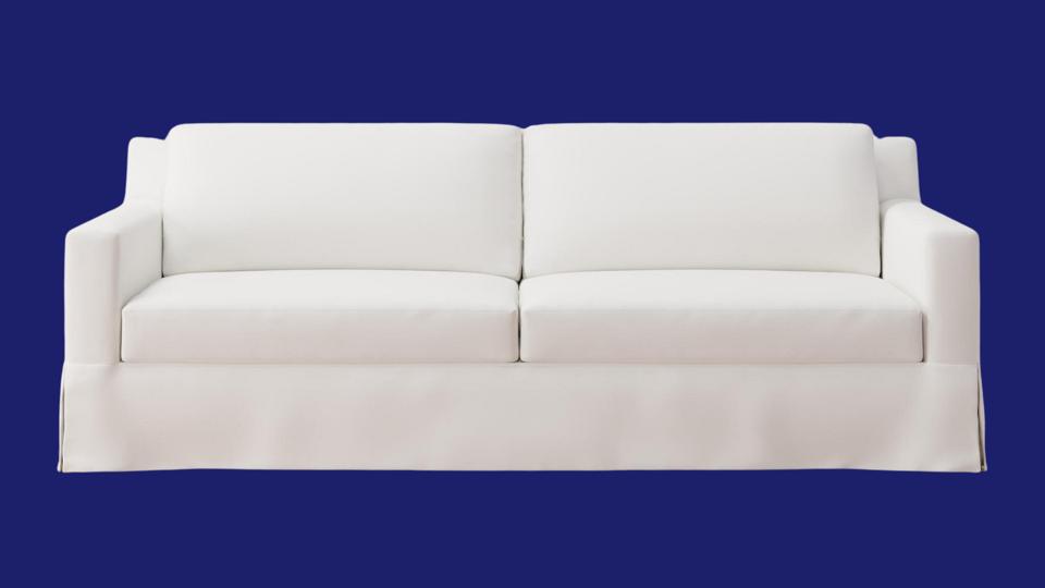 Small white couch against a blue backdrop