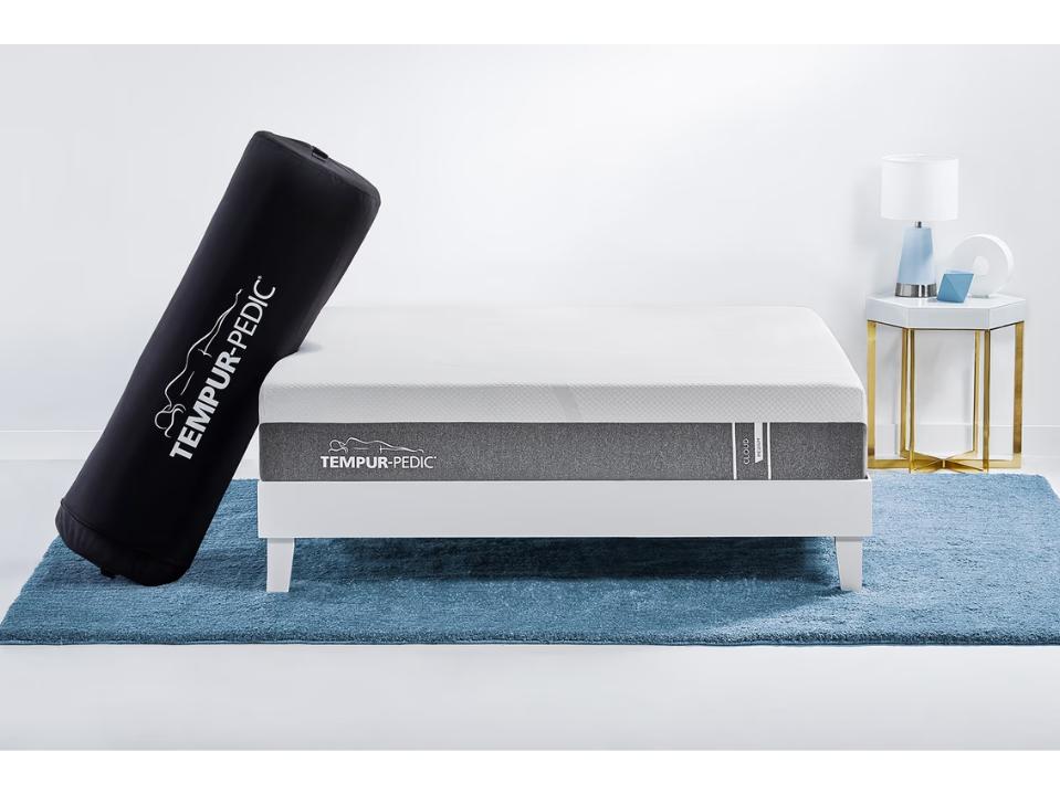 photo of Tempur-Cloud (Queen) mattress w/ case leaning on it on blue carpet in white bedrm