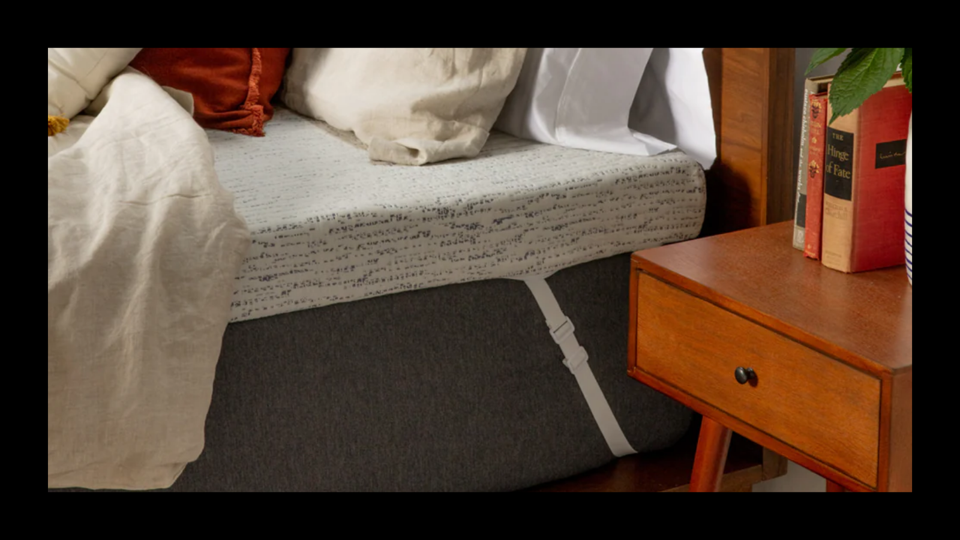 The viscosoft mattress topper on a mattress with pillows on it next to a nightstand