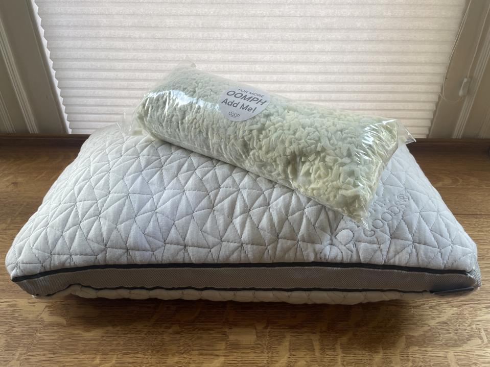 the best pillow overall, the Coop Sleep Goods Pillow, pictured with extra bag of foam for adjustability