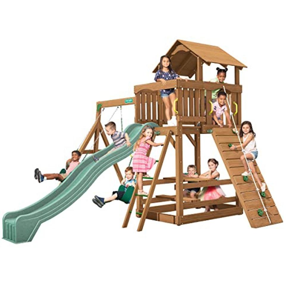 Ten kids climbing on the Creative Playthings Spring Hill Wooden Swing Set 