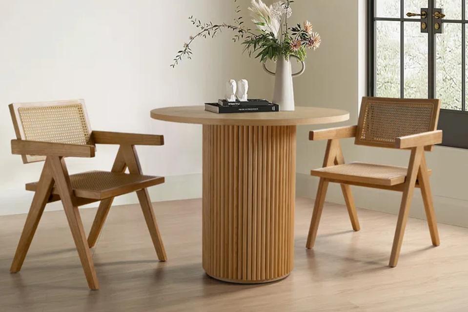 The Gilta Round Dining Table with two rattan side chairs