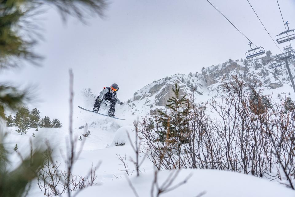 A man jumping in the air while snowboarding