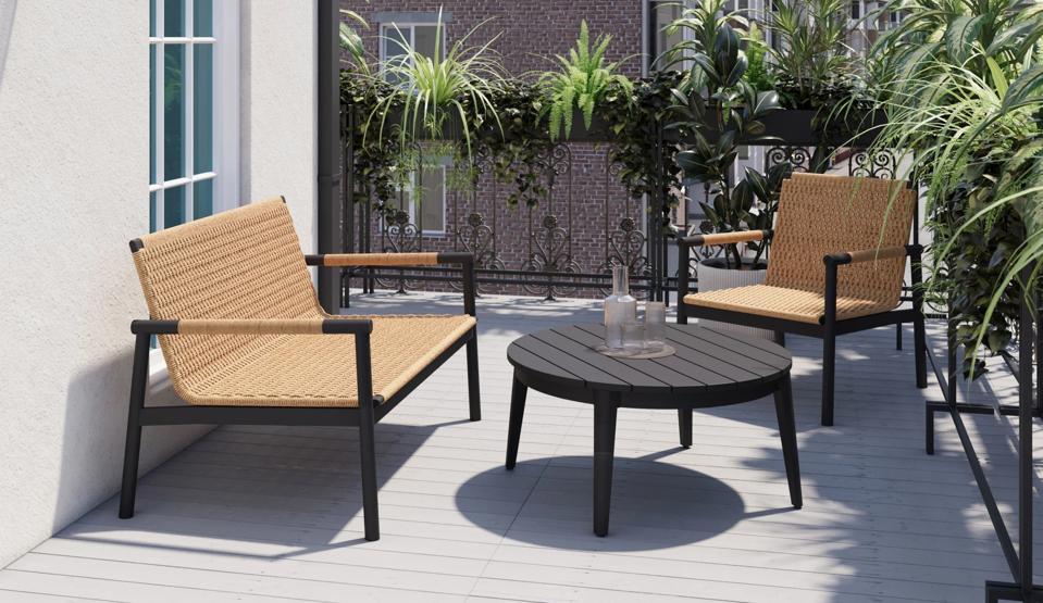 The Wicker + Aluminum Outdoor Flex Collection chair and loveseat on a small balcony