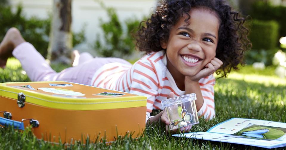 Girl holding a paper butterfly from Little Passports subscription box