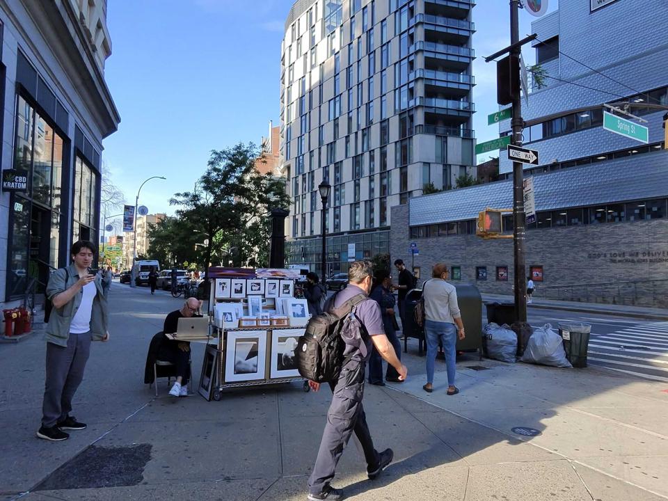 A cityscape of New York with people walking.