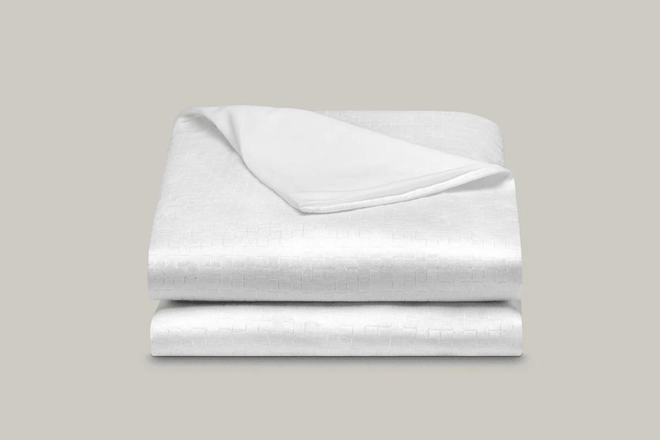 Coop Sleep Goods Ultra-Cool Waterproof Mattress Protector folded on a grey background