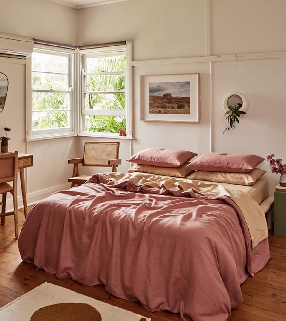 Bed Threads linen sheets rumpled casually on a bed near windows.