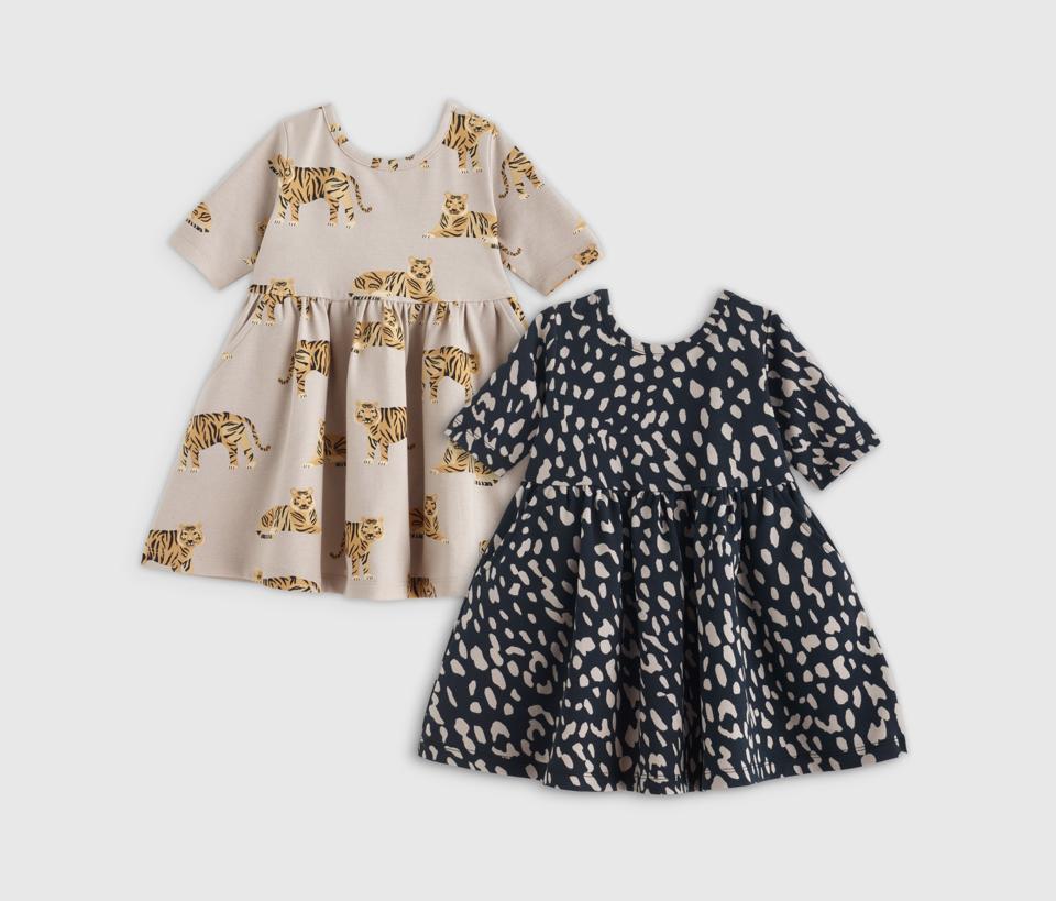 two Quince Organic Cotton Skater Dresses for babies in a tiger and an animal print.